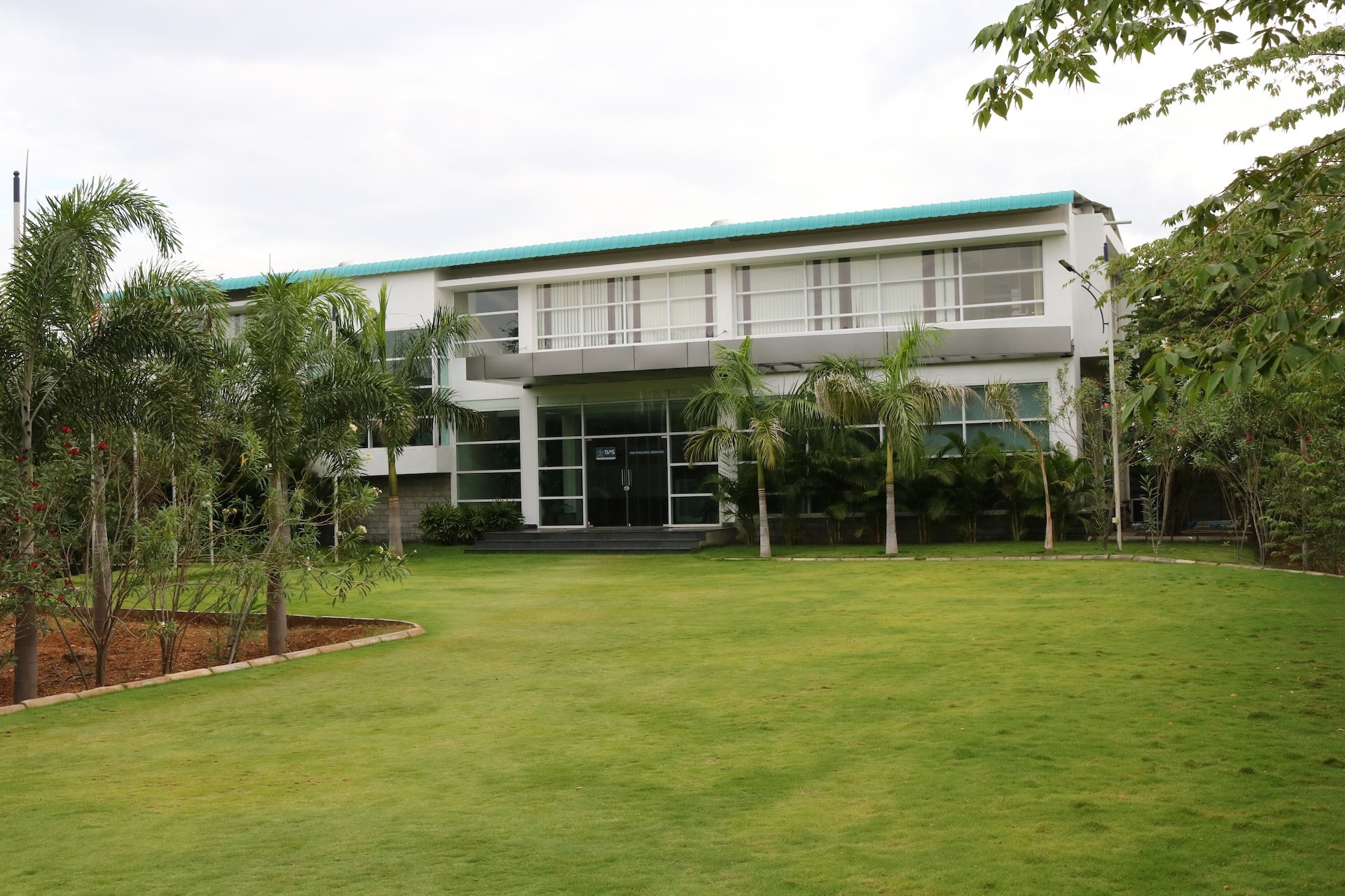 College building exterior with teal roof and manicured lawn