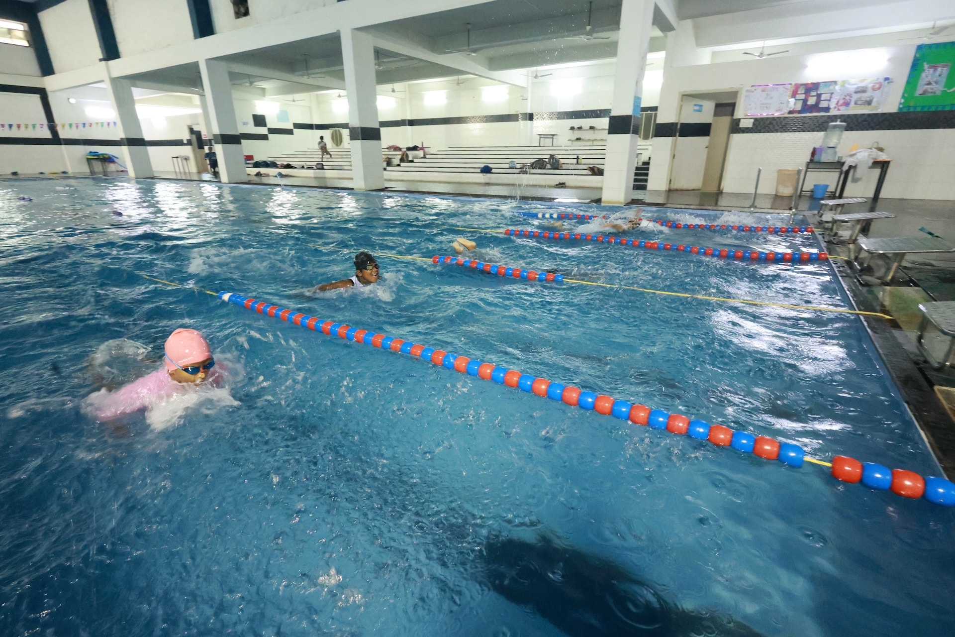 Indoor swimming pool with students in training lanes